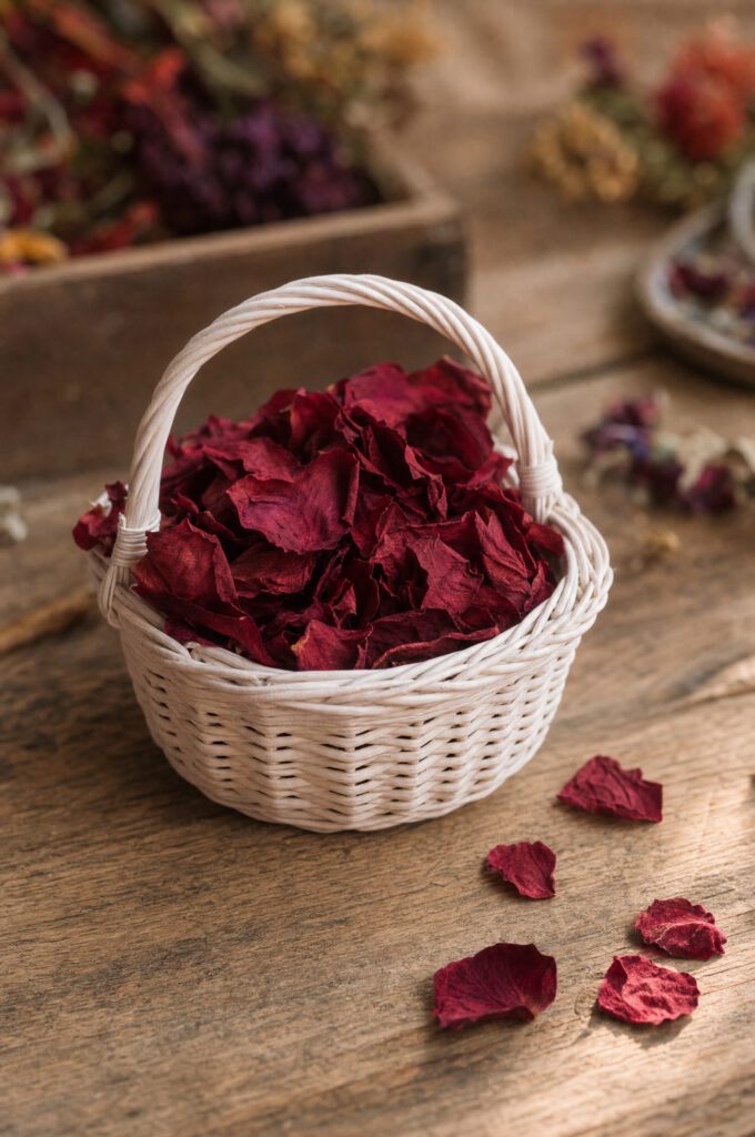 Flower girl basket filled with freeze-dried red rose petals on a wooden florist's bench