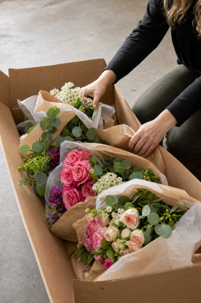 Wholesale flower boxes being opened with fresh stems inside