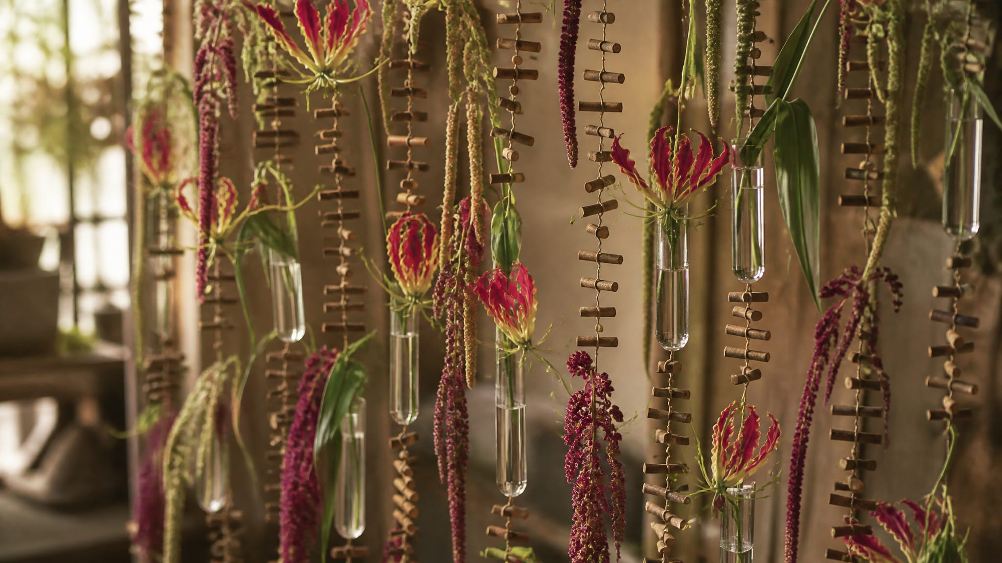 DIY flower curtain made of twig garlands and fresh flowers hanging in a florist's studio