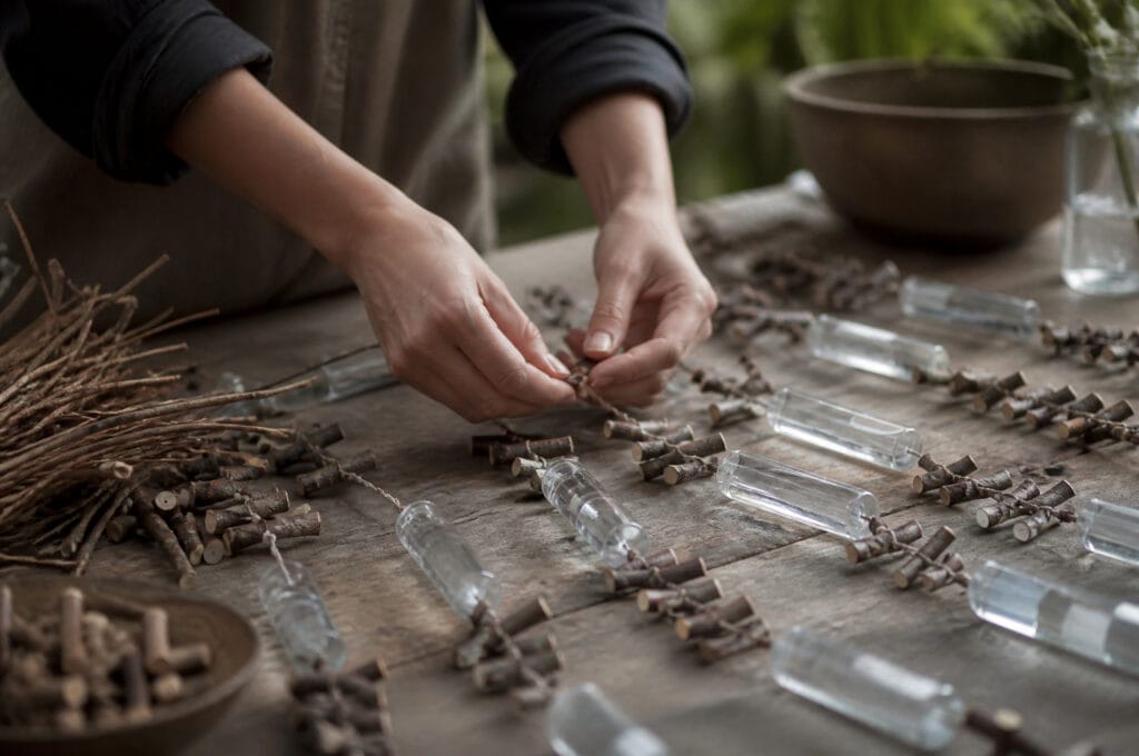 Florist assembling multiple flower curtain garlands by hand at a worktable