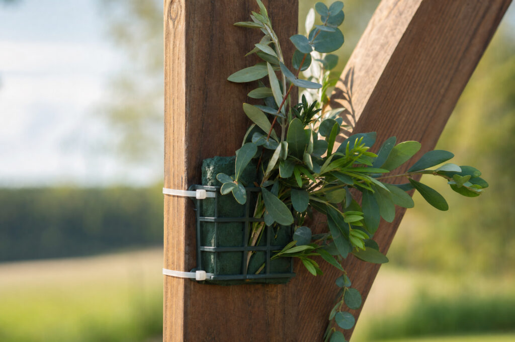 Floral foam cages and zip ties on a wooden worktable, ready for an arch installation