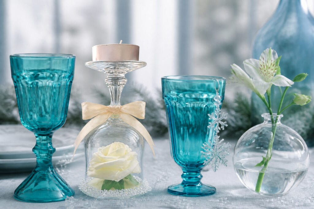Teal glasses glued into a pedestal stand with a snowflake garland and Alstroemeria ornament bulb