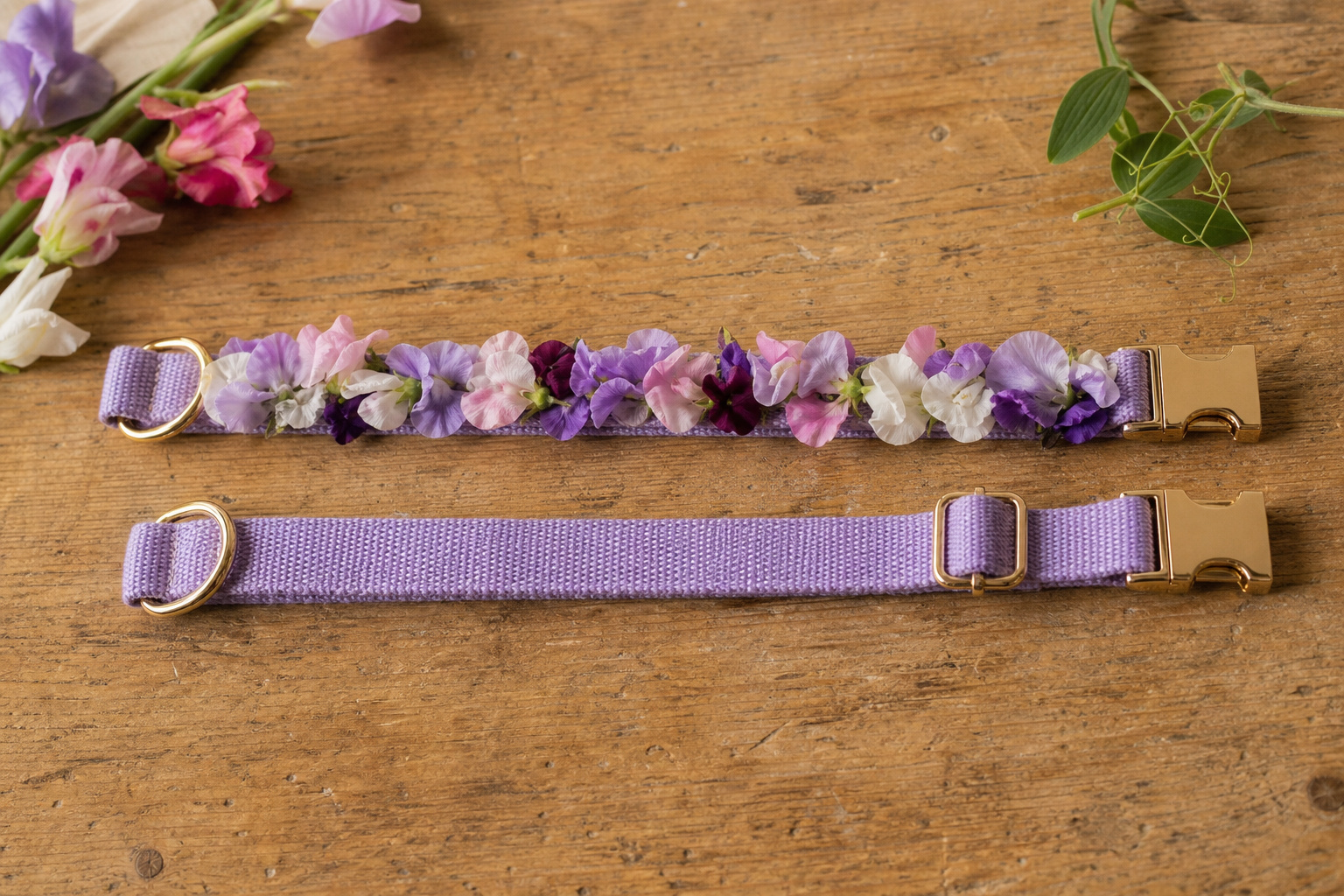 Finished floral dog collar laid flat on a wooden surface next to a plain fabric collar for size comparison