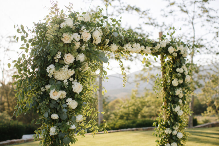 DIY floral wedding arch decorated with garden roses and eucalyptus greenery