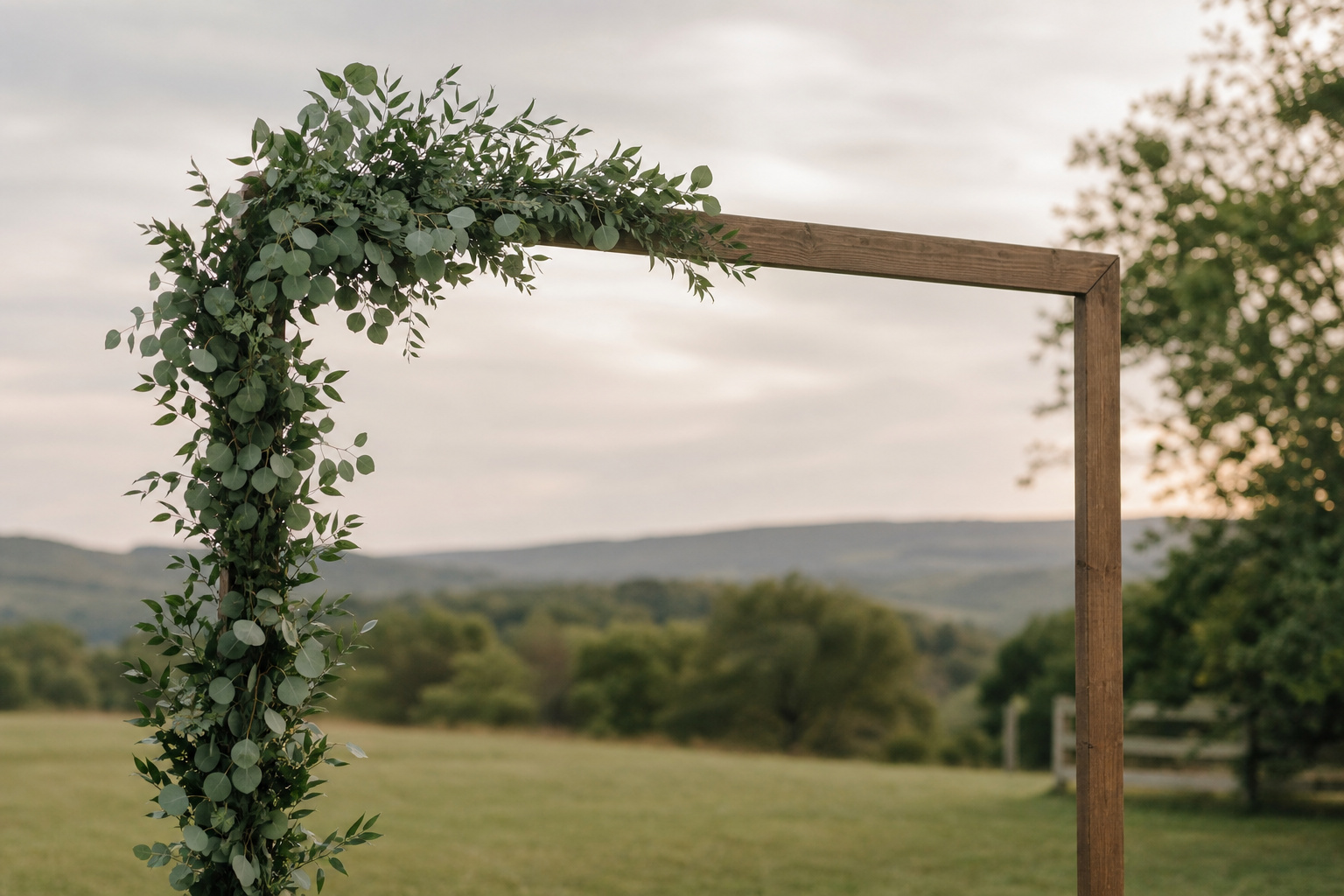 Eucalyptus and Italian ruscus greenery arranged on a simple wooden arch frame