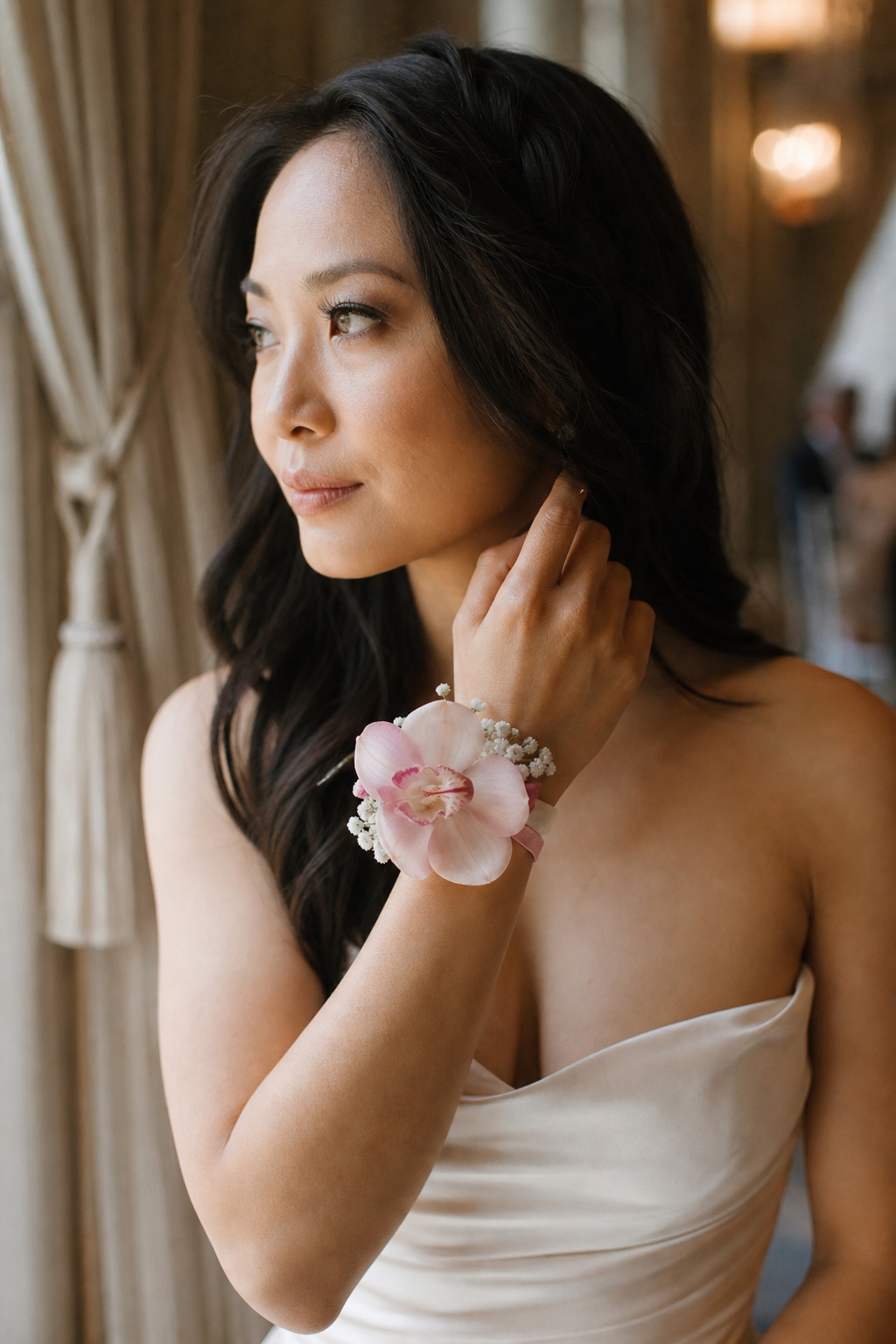 Mother of the bride wearing a wrist corsage at a wedding ceremony