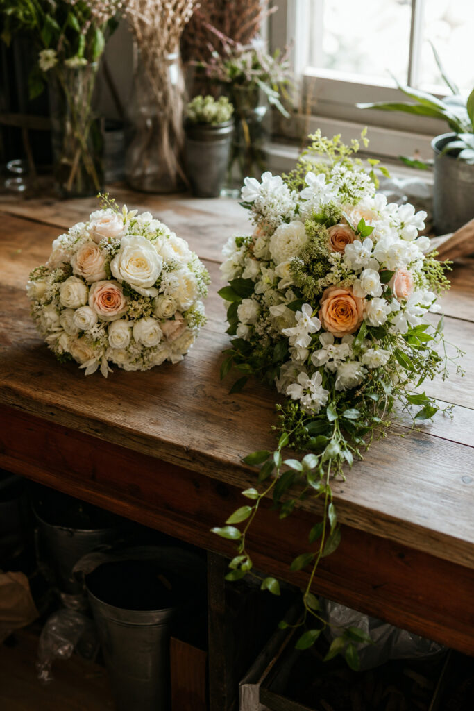 Side-by-side comparison of a cascade bouquet and a round bouquet on a florist worktable