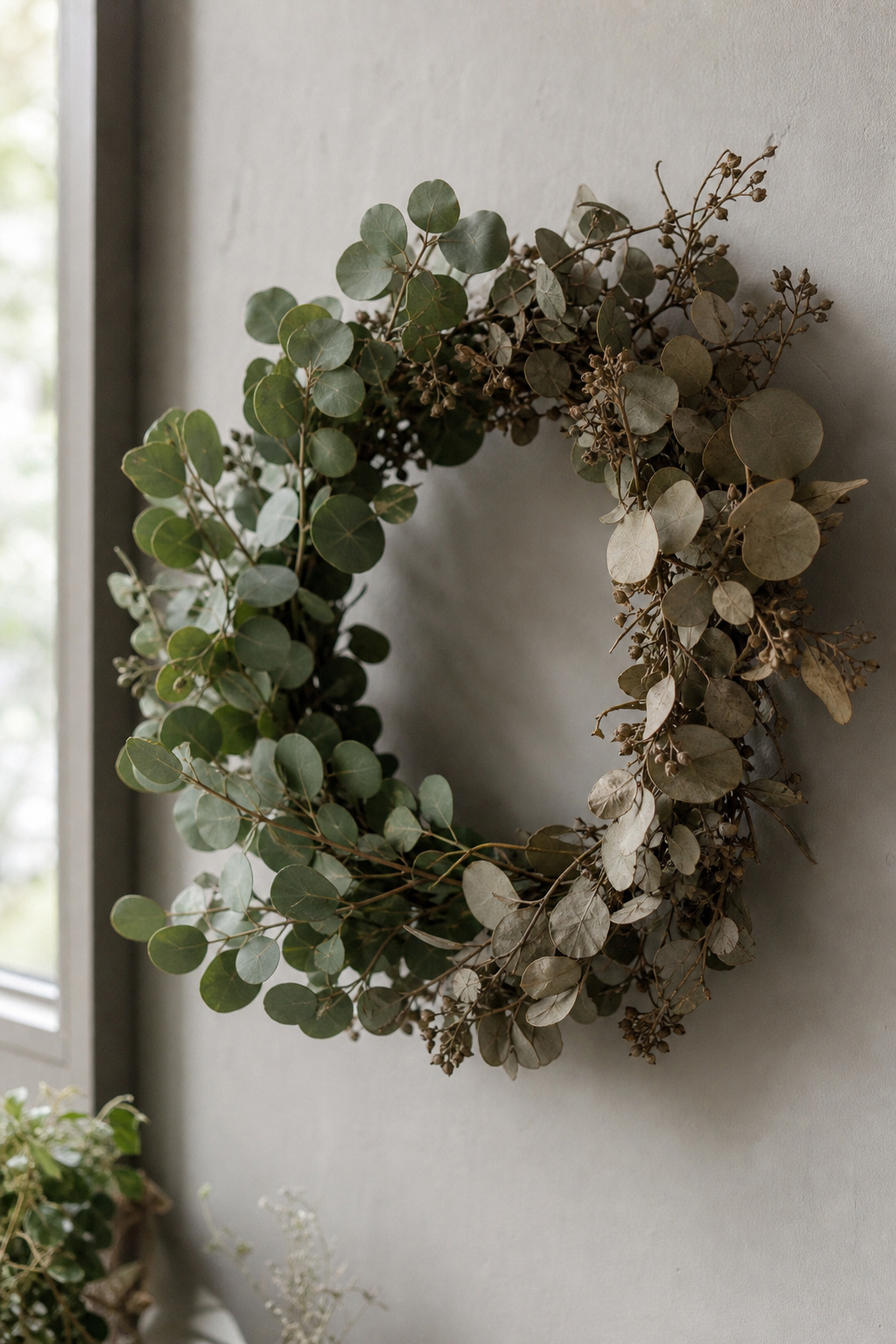Eucalyptus wreath partway through drying, transitioning from green to a muted rustic tone
