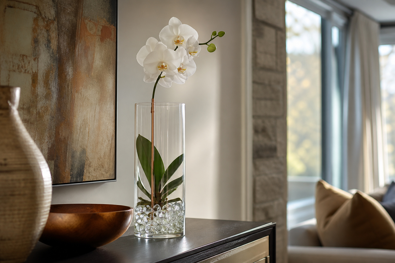 White phalaenopsis orchid styled in a tall glass vase with a copper stake and clear water cubes
