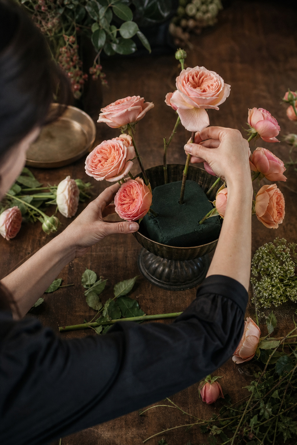 Florist pressing stems into a soaked block of floral foam