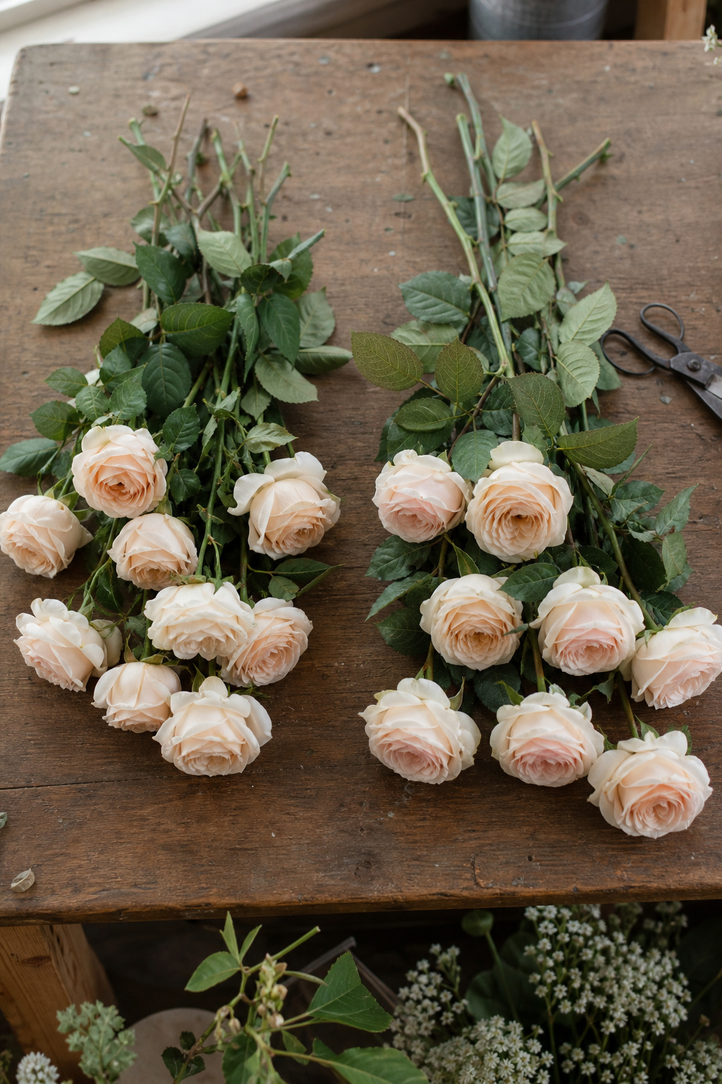 Fresh and silk flower stems laid side by side for comparison on a worktable