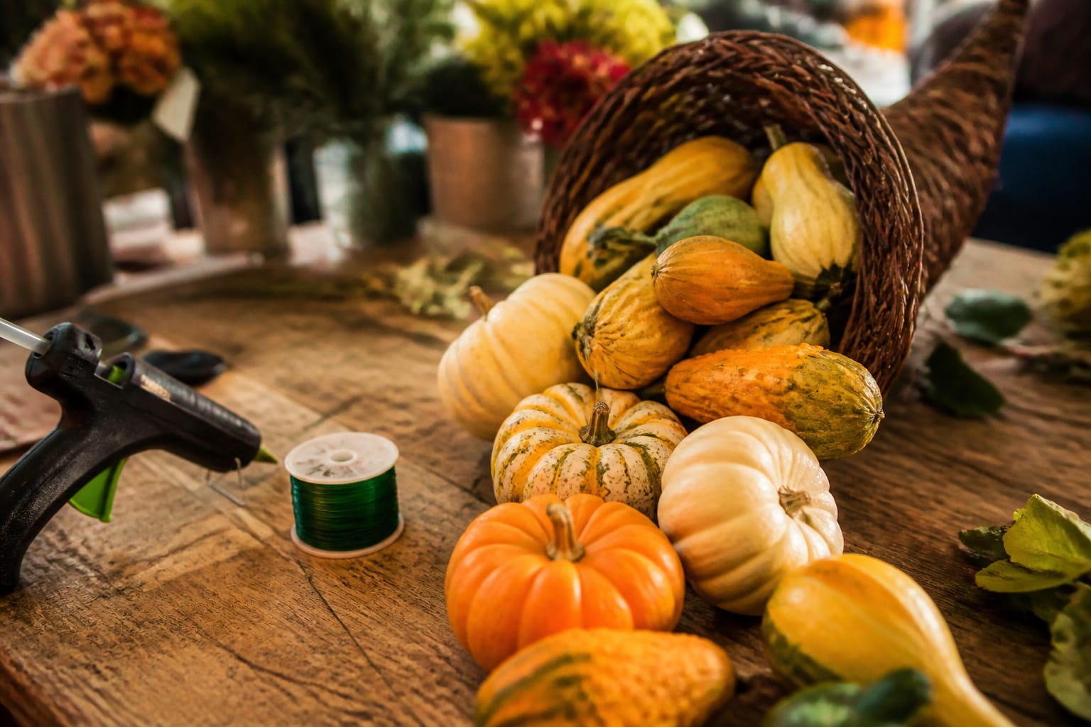 Small pumpkins and gourds wired and glued into a cascading line on a cornucopia arrangement