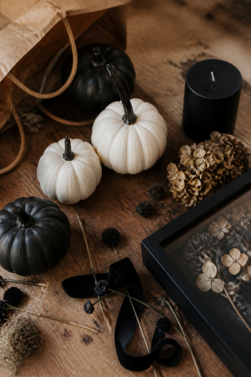Assorted black and white Halloween decor items laid out on a wooden table