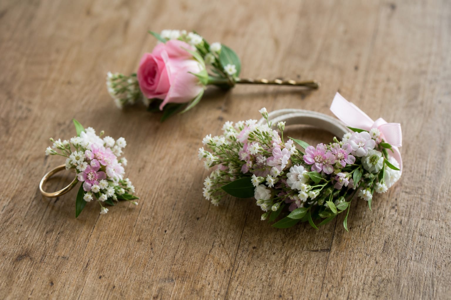Modern wearable prom flowers including a floral ring, bracelet, and hairpin